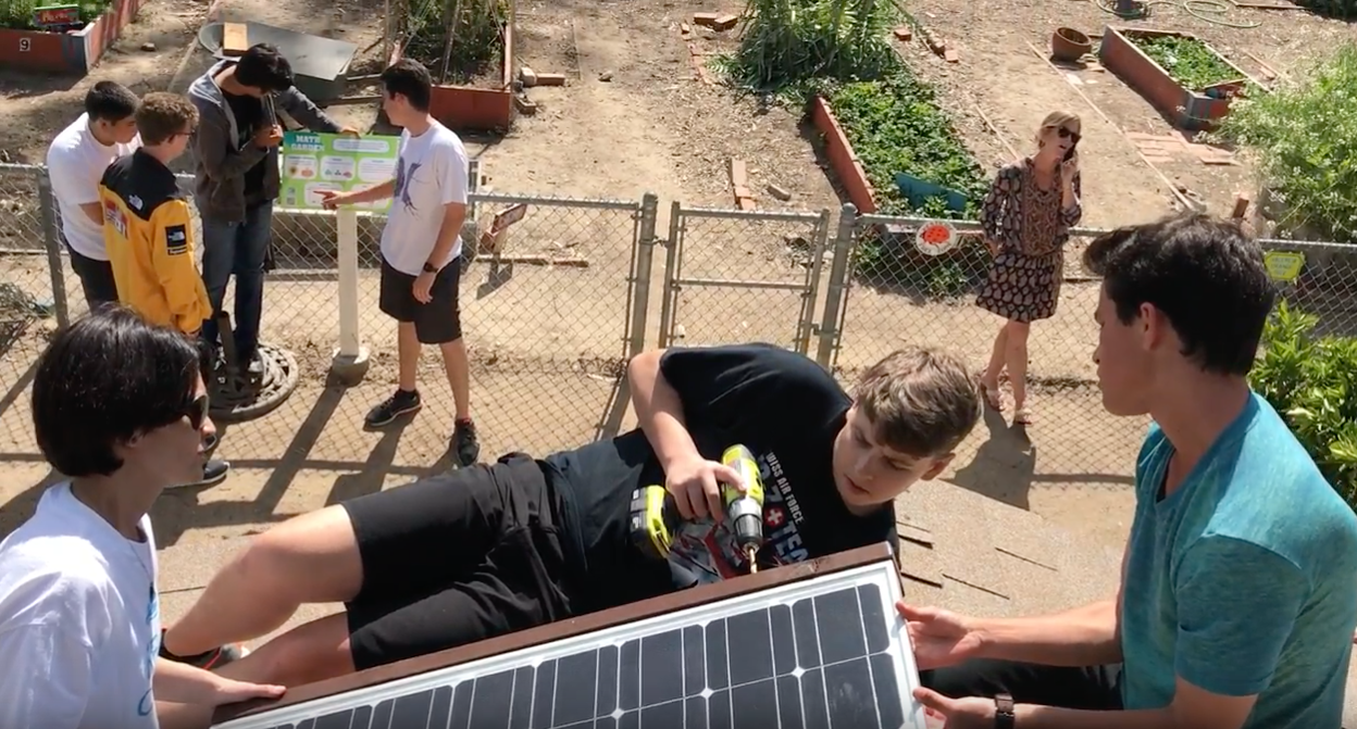 Teacher Jennifer Merritt, Torrey Menne and Ben Sharp work together to secure the solar panel to the roof of the garden shed. Recently, the Rocket Ready program has been implemented district-wide to expose students to real-world situations. 