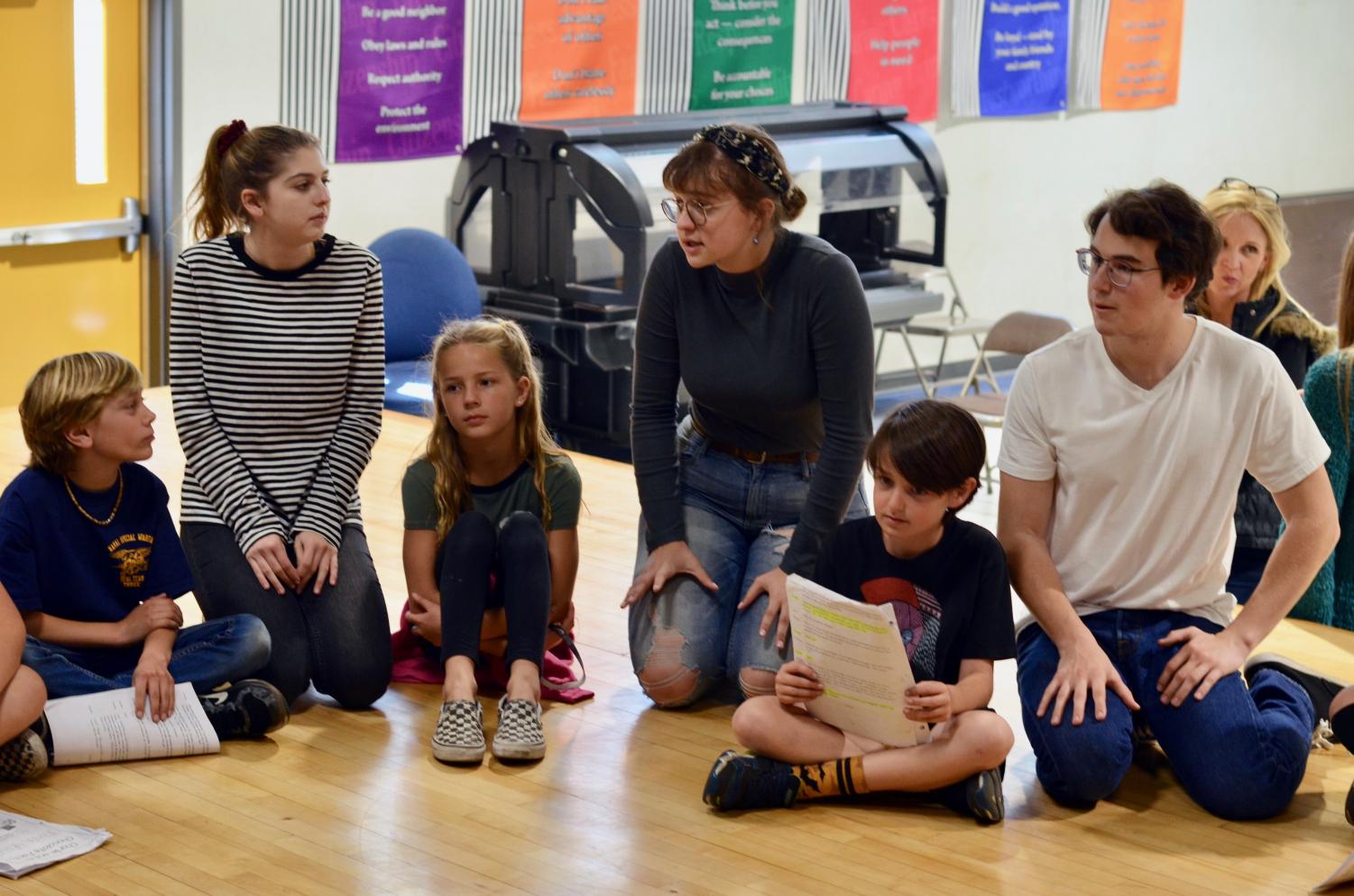 (Left to Right) juniors Kelsey Bailey, Chloe Bryan, and Will Purdy guide a group of elementary kids through their lines. The three, along with five others, extended a helping hand last Thursday with their production of