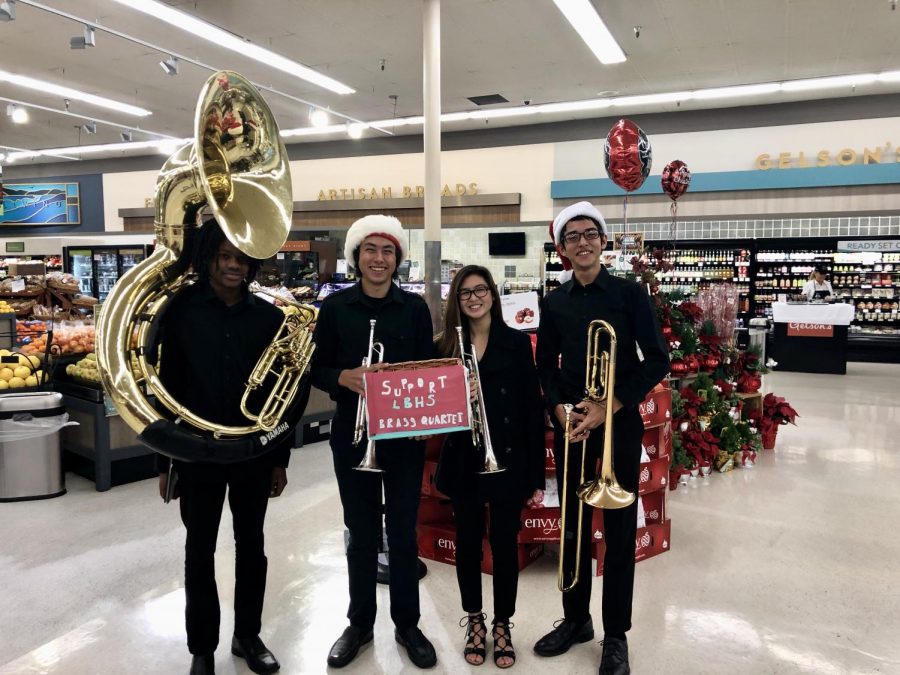 The brass quartet -  Zachary Duncan, sousaphone; Mason Lebby, trumpet; Jordan Sitea, trumpet; and Ryan Davison, trombone - takes a breather between songs at Gelson’s Market. They have also performed at Hospitality Night, Trader Joe’s, and the teachers’ annual holiday breakfast.