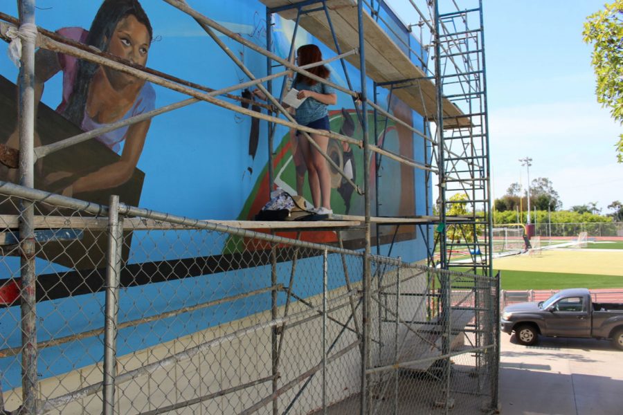 In the process of painting, an LCAD art student assists in the creation of “Momentum,” by muralist Timothy Smith (@timothyrobertsmith). Smith and eight students completed the work over a 12-day span. 