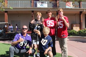 Brian Carlson poses in his jersey with LBHS students for Spirit Week.