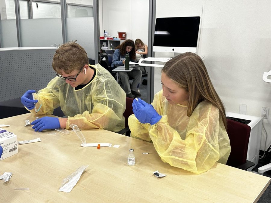 Tess Smialowicz and Reed Franz working on needle safety during Rachel de Leon’s Medical Core class. De Leon has been a nurse for 30 years prior to teaching at LBHS.