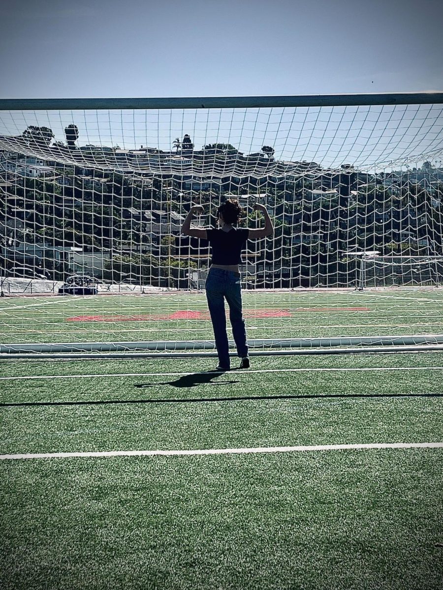 A student stands in front of an LBHS goal flexing their muscles. (Student in image: Verity Foster)